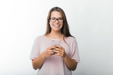 Akıllı telefon tutan ve kameraya bakarak büyüleyici genç kadın Portresi, Blogger bir makale göndermek için hazır 