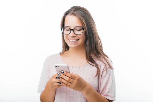 Retrato de mulher sorridente alegre usando seu smartphone sobre fundo branco — Fotografia de Stock