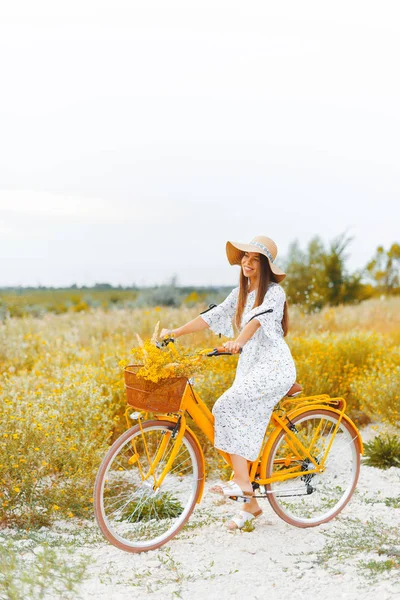 Foto de estilo vintage de una mujer joven, en una bicicleta amarilla, con — Foto de Stock
