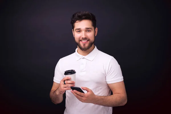 Portrait de jeune homme souriant gai avec barbe tenant tasse de — Photo