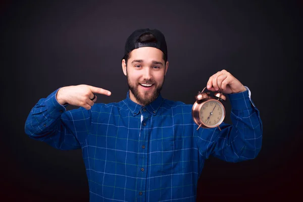 Foto de jovem alegre apontando para o despertador — Fotografia de Stock