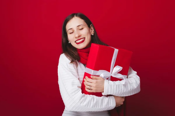 Glückliche junge Frau in Winterkleidung mit rotem großen Geschenk — Stockfoto