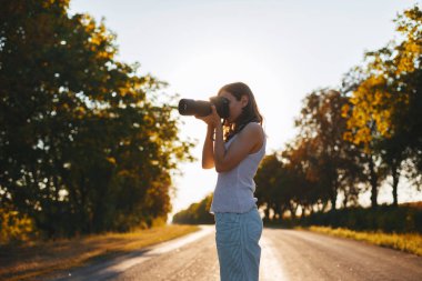 Yakışıklı genç kadın, yolun ortasında duran ve phot alarak