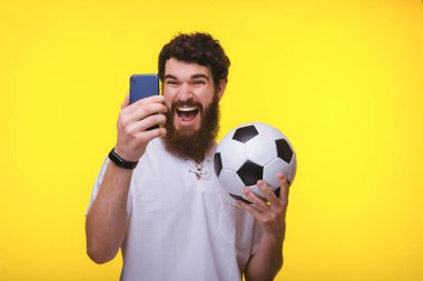 Neşeli sakallı adam fotoğrafı, m kullanırken futbol topu tutan