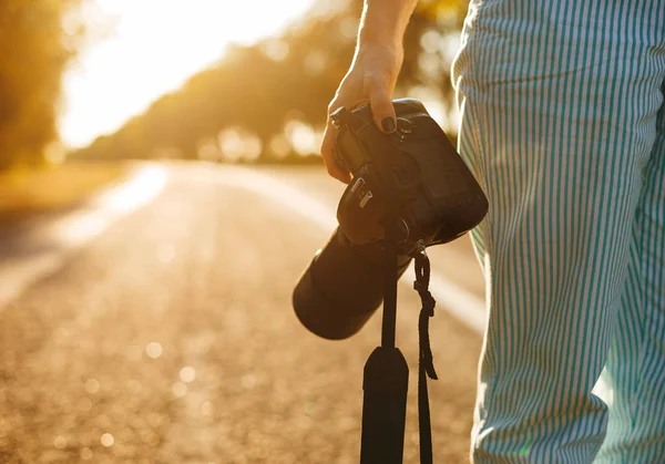 Knap meisje reist en houdt haar camera,, zonsondergang lichten b — Stockfoto