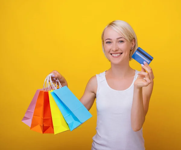 Foto av glad ung blond kvinna, hålla shoppingväskor och — Stockfoto