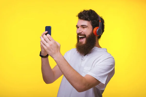 Photo de l'homme étonné avec la barbe en regardant son smartphone — Photo