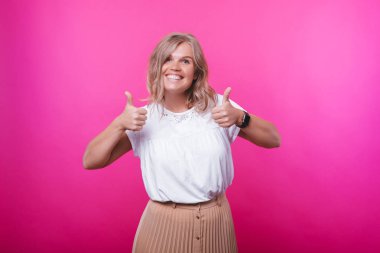 Pembe arka plan üzerinde gülümseyen sarışın kadın portresi