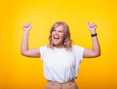 Çığlık genç sarışın kadın, ayaklanmış elleri ile, üzerinde kutluyor