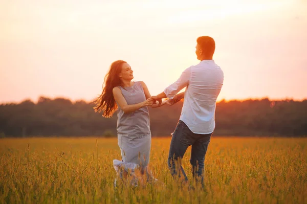 Foto eines Paares, das bei Sonnenuntergang in einer Datei tanzt und Spaß hat — Stockfoto