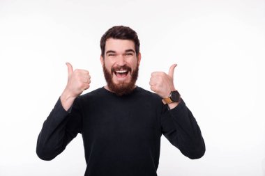 Gülümseyen genç adam beyaz arka plan üzerinde başparmak gösteren