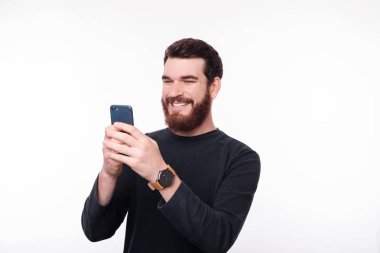 Neşeli sakallı adam rahat onun telefon kullanarak