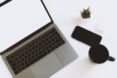 Beyaz masada dizüstü bilgisayar, akıllı telefon ve kahve fotoğrafı