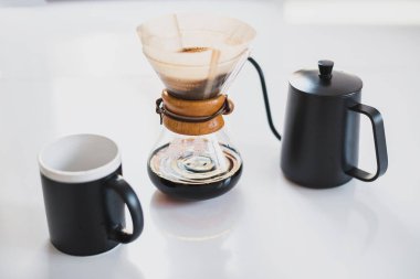 Beyaz mutfak masasına kahve seti üzerine dökün