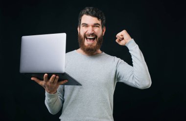 Happt genç adam başarı kutluyor ve yeni dizüstü tutan