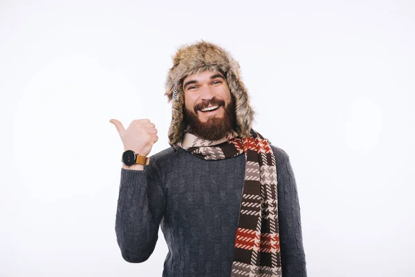 Szczęśliwy brodaty mężczyzna pokazuje kciuk w szaliku i czapce narciarskiej. — Zdjęcie stockowe