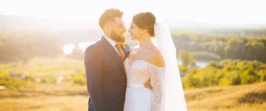 Gelin ve damat tarlada birbirlerine bakıp gülümsüyorlar..