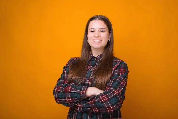 Retrato de una joven alegre con brazos cruzados sobre fondo amarillo — Foto de Stock