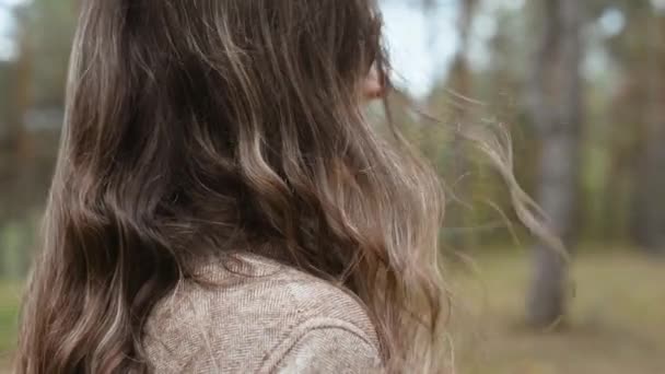 Närbild bilder av kvinna som står i skogen och tittar någonstans — Stockvideo