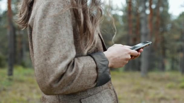 Imagini cu o femeie tânără în parc folosind smartphone-ul ei — Videoclip de stoc