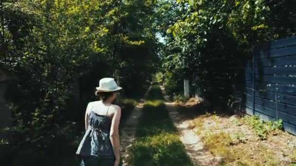 Vídeo de jovem caminhando na pequena rua da aldeia — Vídeo de Stock