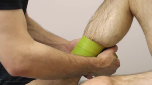 Footage of man making tape or flossing leg, kinesiology — Stock Video