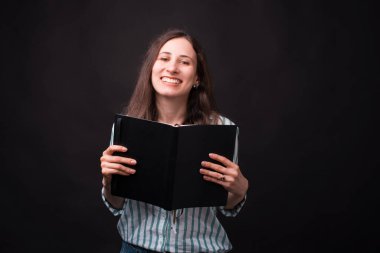 Gülümseyen kızlar siyah arka planda günlüğünü veya kitabını severler.