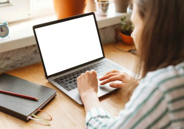 Beyaz ekran bir dizüstü bilgisayarın ve iş yerinde yazan ellerin fotoğrafını kapat.