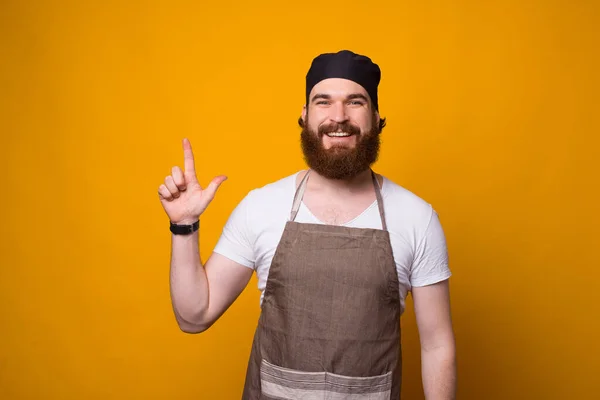 Portrait of cheerful Chef man pointing away at copyspace