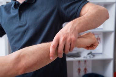 Fizyoterapist dolabındaki bir kolu kontrol ediyor..