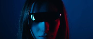 Bir gözlüklü, kırmızı ve mavi ışıklı ciddi bir genç kadının portresini yakından çek.