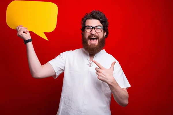 Aufgeregter Bärtiger Hipster Zeigt Auf Eine Gelbe Blase Während Über — Stockfoto