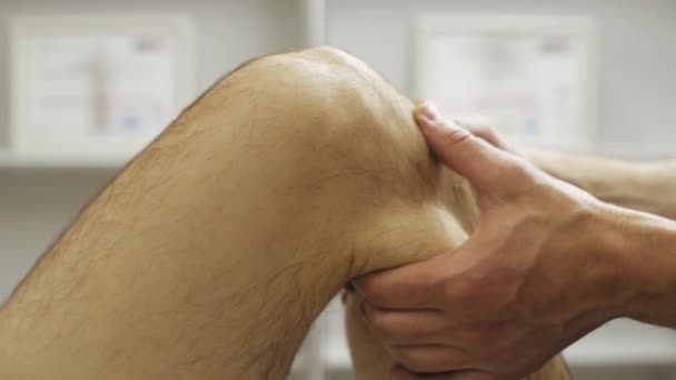 Footage of professional man making physical therapy on knee — Stock Video