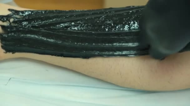 Filmación de una mujer haciendo azúcar en la pierna con pasta negra — Vídeo de stock
