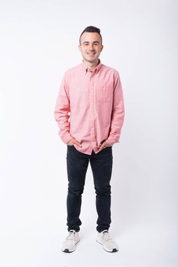 Beyaz arka planda dikilip kameraya bakan genç ve yakışıklı bir adamın portresi.