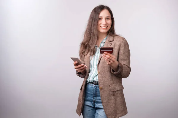 Cheerful young woman in casual showing her new debit card and smiling — Stock Photo, Image