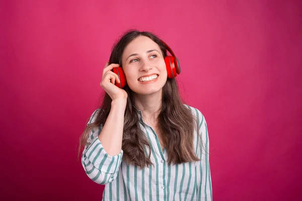 Boldog mosolygó nő fülhallgatón keresztül hallgatja a zenét. — Stock Fotó