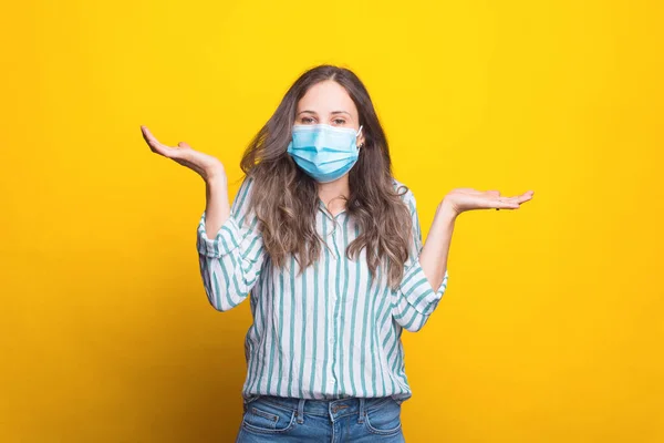 Jovencita usando máscara médica está haciendo no sé gesto — Foto de Stock