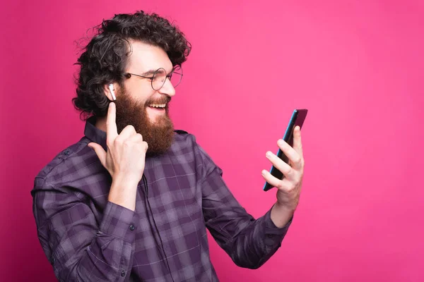 Portrait de gai bouclé gars en utilisant des écouteurs et en regardant la tablette — Photo