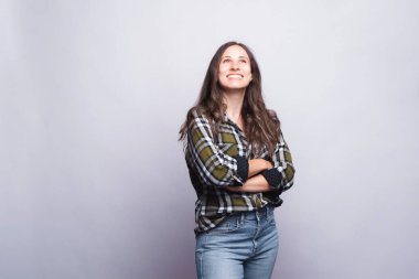 Beyaz arka planda kollarını kavuşturmuş genç bir kadının portresi.