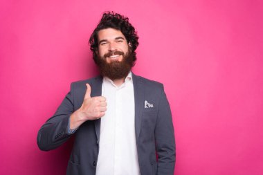 Sakallı, genç bir adamın portresi baş parmağını gösteriyor..