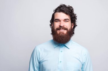 Gömlekli sakallı adamın portresi kameraya kendinden emin bakıyor..