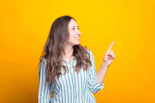 Schattige Glimlachende Jonge Vrouw Wijst Opzij Gele Achtergrond — Stockfoto