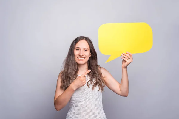 Portrait of happy woman on white background holding speech bubble.