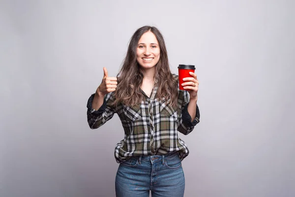 Llévate el café. Feliz joven mostrando el pulgar hacia arriba y sosteniendo — Foto de Stock