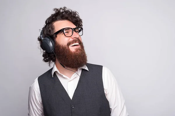 Foto de cerca del joven hombre de negocios que usa auriculares y liste — Foto de Stock