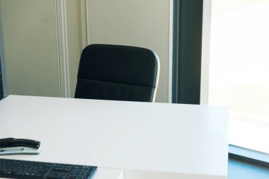 Çalışma odasının, beyaz masanın ve siyah sandalyenin fotoğrafını çek..