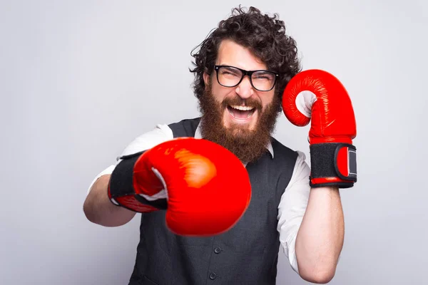 Fotografie muže s vousy v obleku a děrování s boxerskými rukavicemi — Stock fotografie