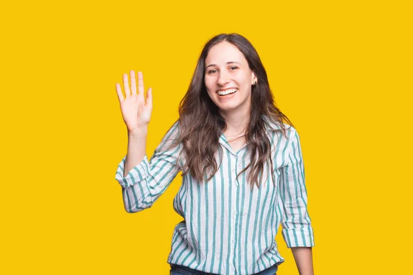 Charmante glimlachende jonge vrouw in causaal gezegde HELLO over gele achtergrond — Stockfoto