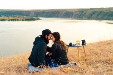 Nehir kenarında piknik yapan genç ve güzel bir çiftim.